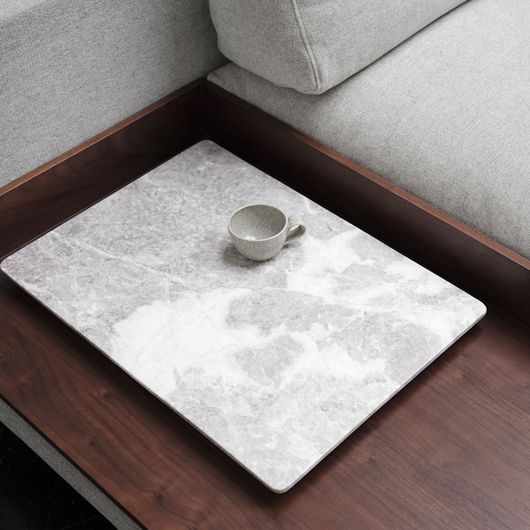 Gray marble serving tray with subtle white veining, featuring a small ceramic cup. Minimalist design on wooden table.