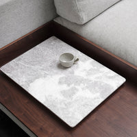 Gray marble serving tray with subtle white veining, featuring a small ceramic cup. Minimalist design on wooden table.