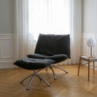 Gray fabric lounge chair with a minimalist design, featuring a sleek metal base and smooth, simple textures.