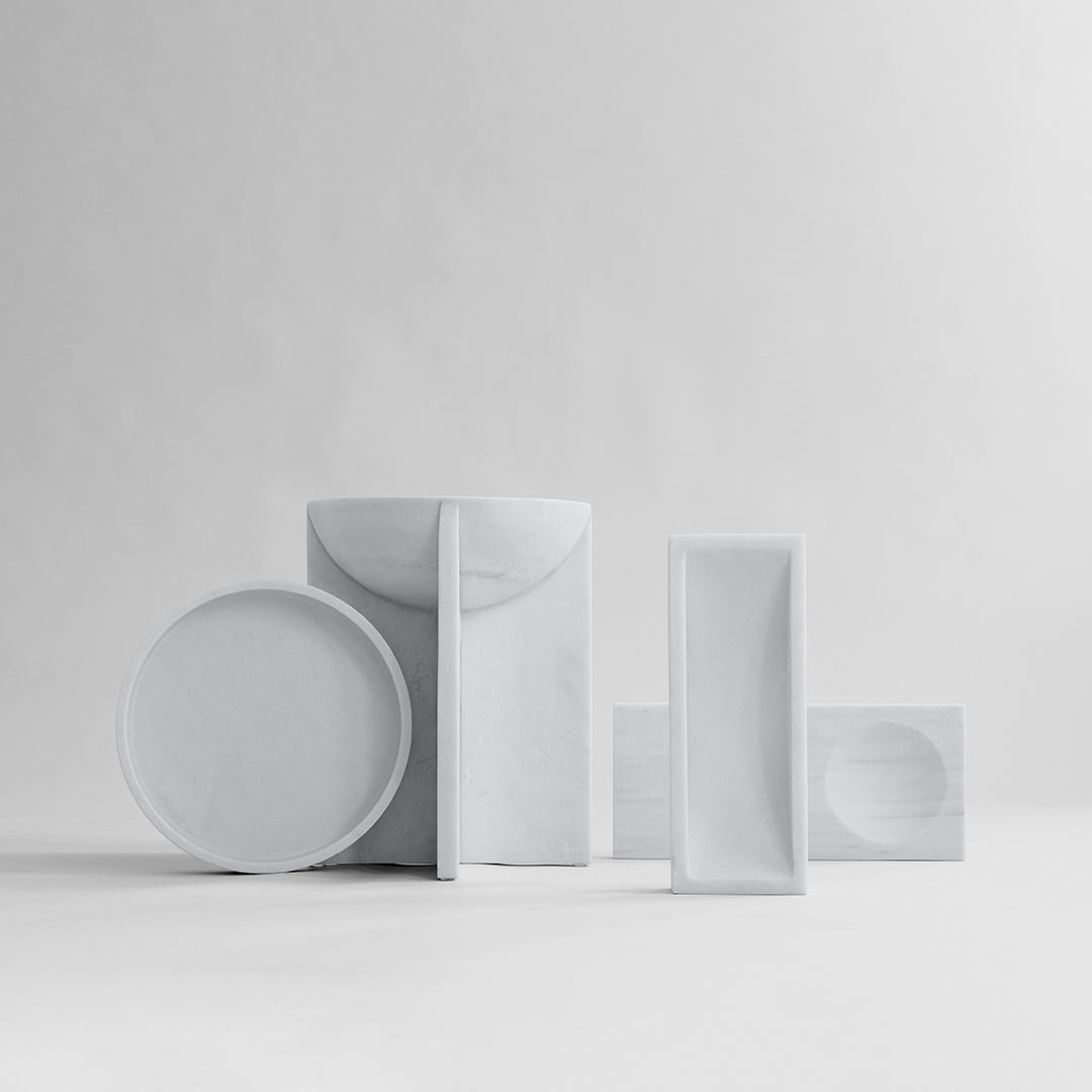 White ceramic tableware set with modern shapes and smooth textures, featuring various minimalist designs.