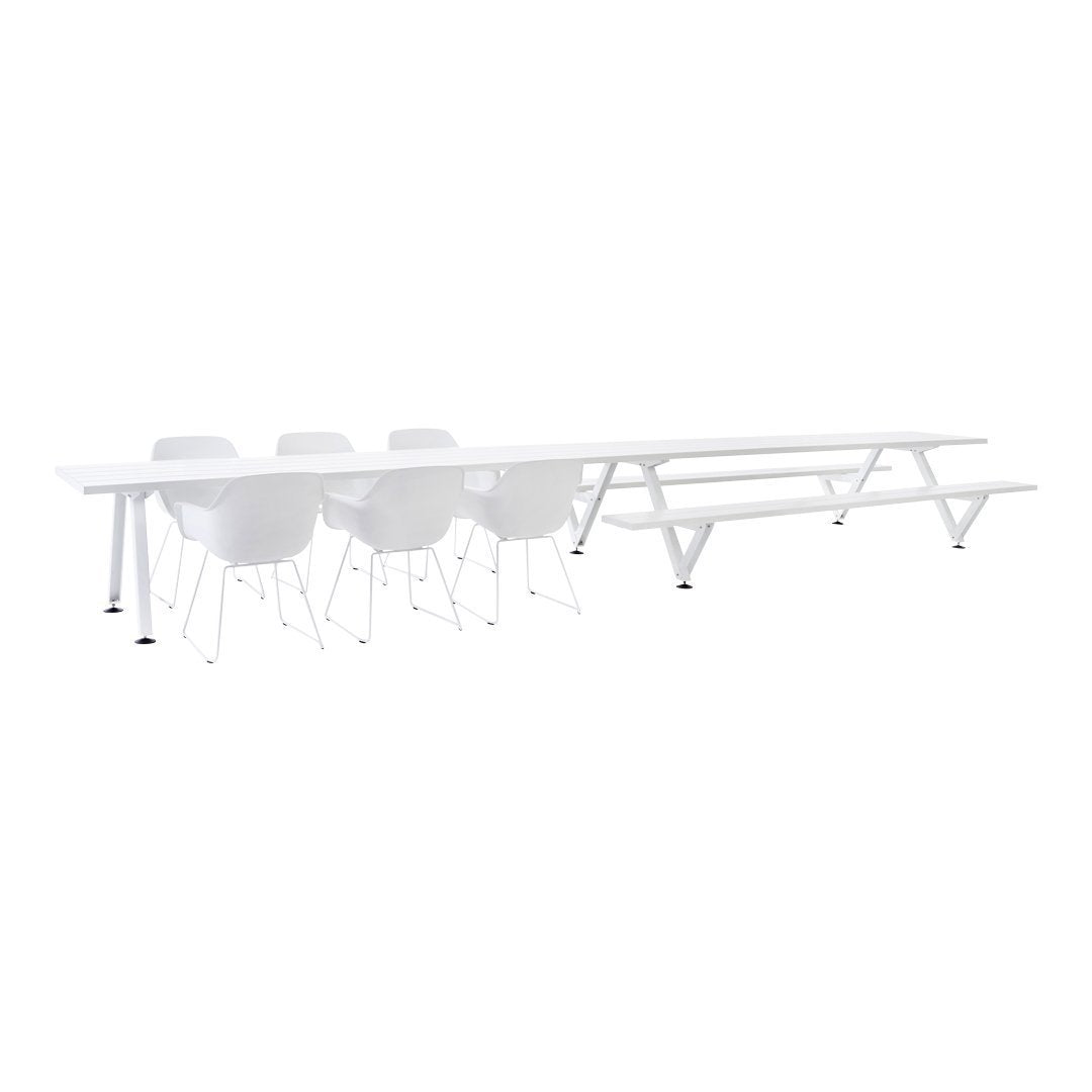 Long white dining table with white chairs, featuring a sleek minimalistic design and smooth surfaces.