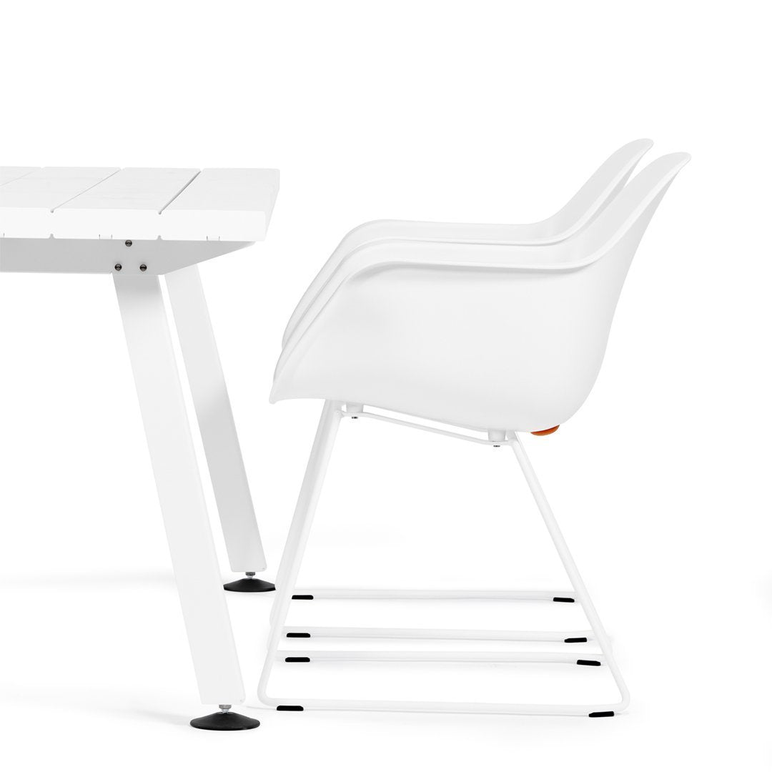 White modern chair with smooth curves paired with a sleek white table, creating a minimalist aesthetic.