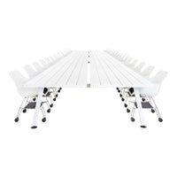 Long white table with a smooth surface and minimalist design, featuring curved white chairs on chrome wheels.