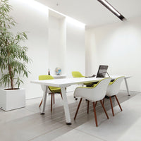 Modern white office table with green chairs, featuring sleek lines and minimalistic design against a bright, neutral backdrop.