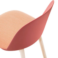Coral pink seat with a textured peach upholstery and light wooden legs, offering a modern, stylish look.