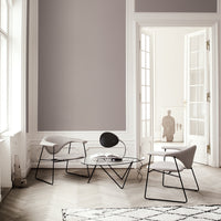 Light gray walls, minimalist black and gray furniture, and a geometric patterned rug create a modern, stylish ambiance.