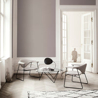Elegant gray walls with minimalist black and white furniture. Soft neutral tones and geometric patterns on the rug.