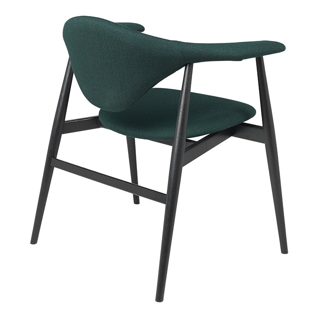 Dark green fabric chair with a unique silhouette and contrasting black legs, showcasing a modern, minimalist design.