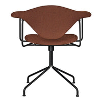 Rust-colored upholstered chair with a modern design, featuring a black metal base and sleek curved lines.