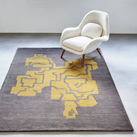 Gray area rug featuring bold yellow geometric patterns, adding modern flair to any space.