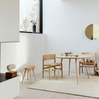 Light wood furniture in a minimalist setting with neutral tones and soft textures, featuring organic shapes and patterns.