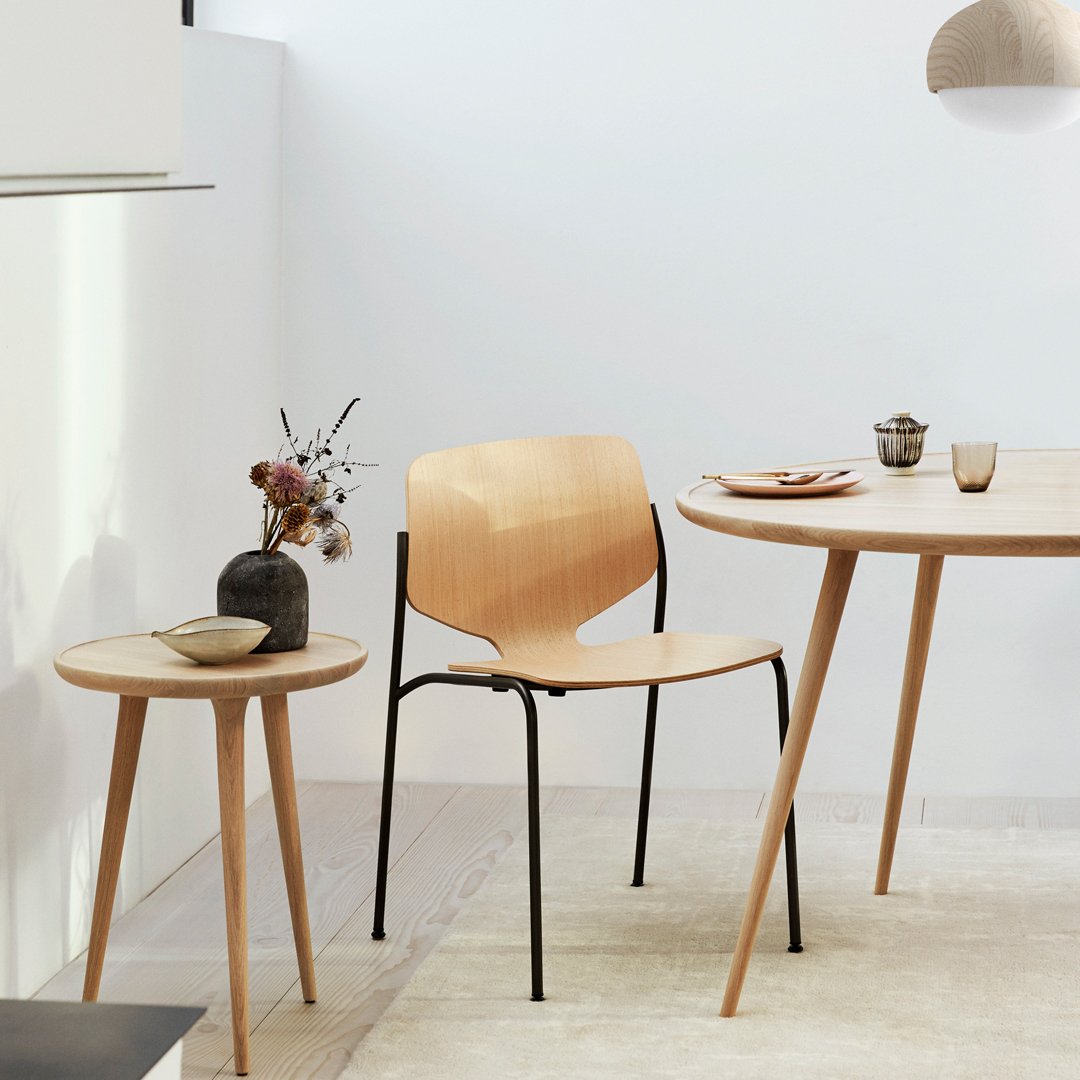 Light wood chair and table with natural finishes; minimalistic design featuring soft curves and clean lines in a neutral setting.