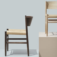"Two modern wooden chairs: one dark finish with woven seat, one light finish with natural seat, against a pale backdrop."