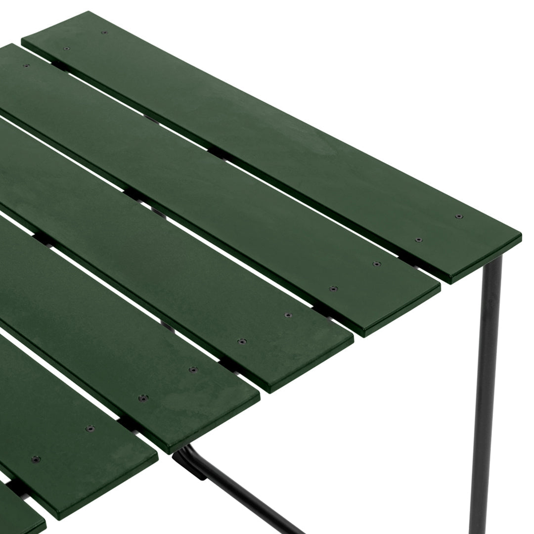 Close-up of a slatted table in deep green with a sleek, minimal design and black metal frame. Perfect for outdoor use.