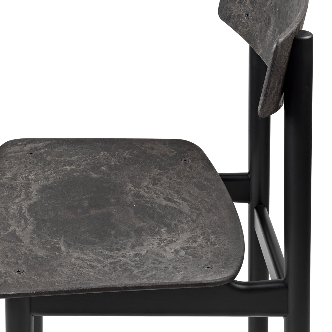 Black metal chair with a textured dark gray seat, featuring a smooth, natural stone pattern.