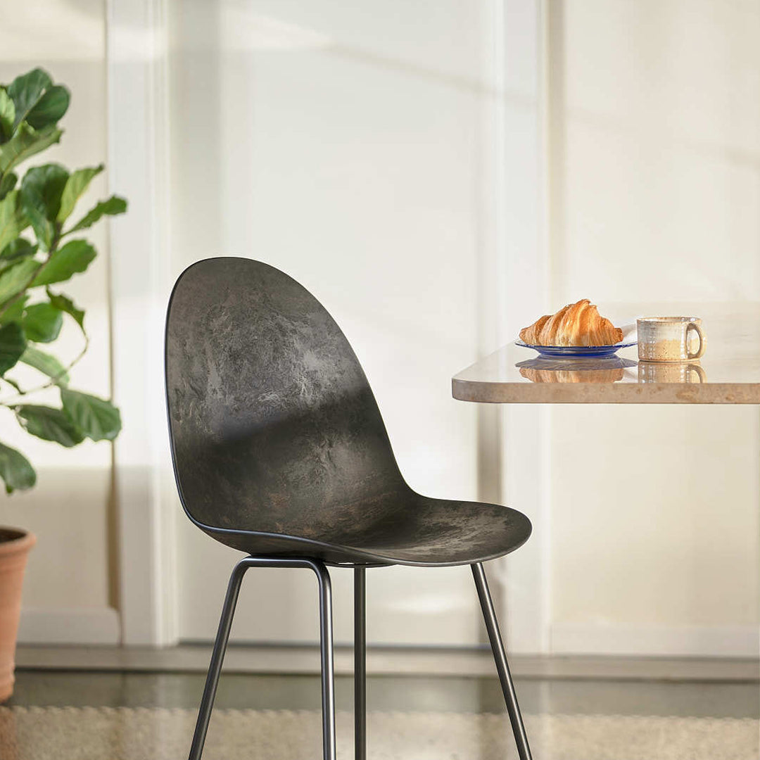 Stylish black chair with a sleek, smooth surface, complementing a cozy table setting with neutral tones.