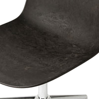 Black textured chair seat with subtle patterns and a shiny chrome base. Modern design element for any space.