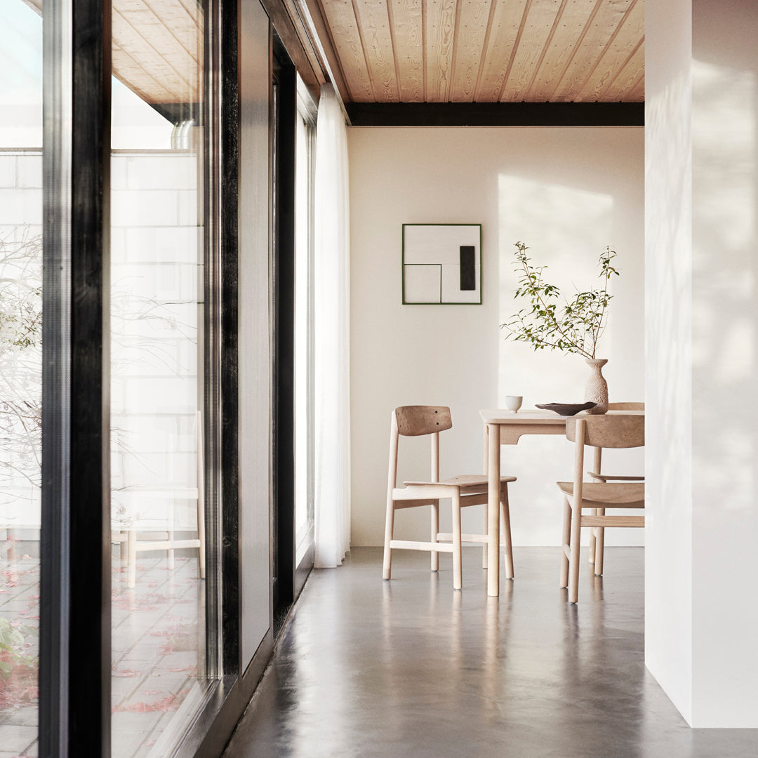 Minimalist interior featuring light wood tones, soft neutral walls, and natural light enhancing simple patterns.