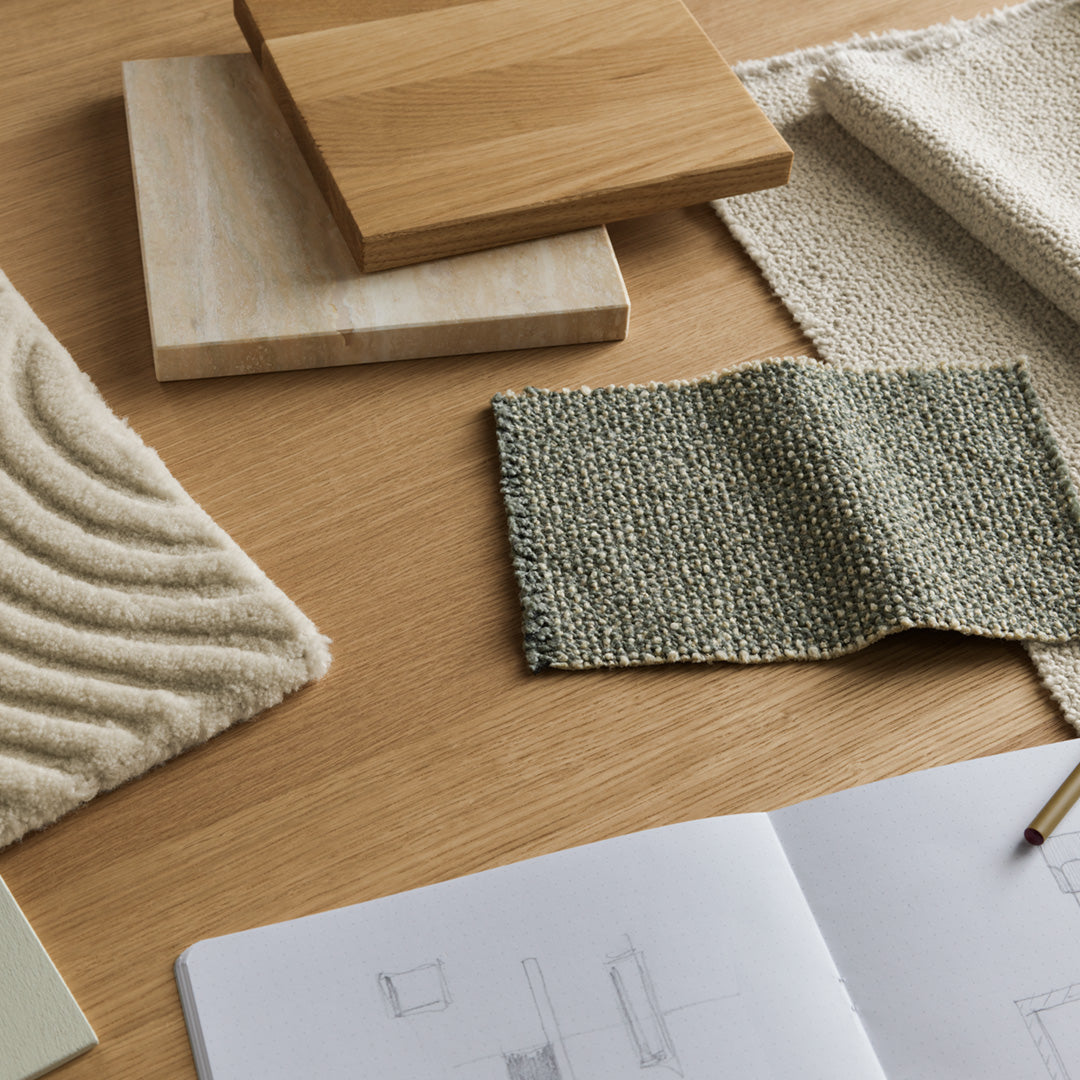 Neutral tones of beige, green, and natural wood with textured patterns on fabrics and surfaces create a serene aesthetic.