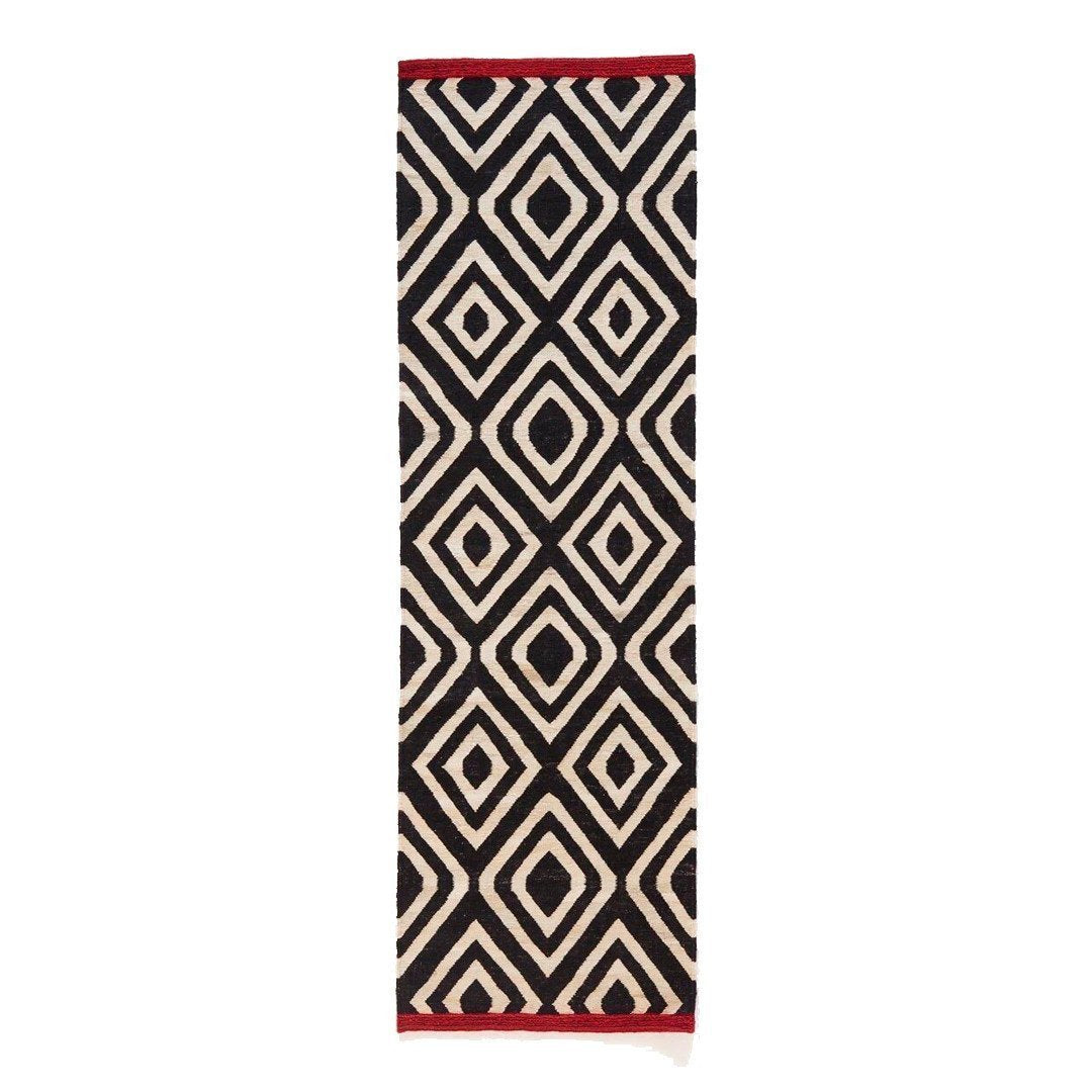 Black and cream diamond pattern runner rug with a red border for modern home decor.