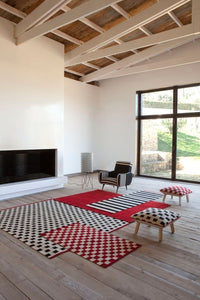 Red and black checkered patterns on rugs, creating a stylish contrast against a modern living space.