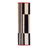 Black and white striped rug with a bold red border, featuring geometric patterns for a modern design.