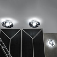 Chrome ceiling lights with modern, geometric patterns against a sleek, dark wall. Bright illumination accents design.