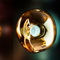 "Amber glass pendant lamp with a swirling pattern, reflecting golden hues and soft light."