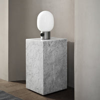 Modern marble lamp base with sleek white glass shade, featuring a minimalist design and neutral color palette.