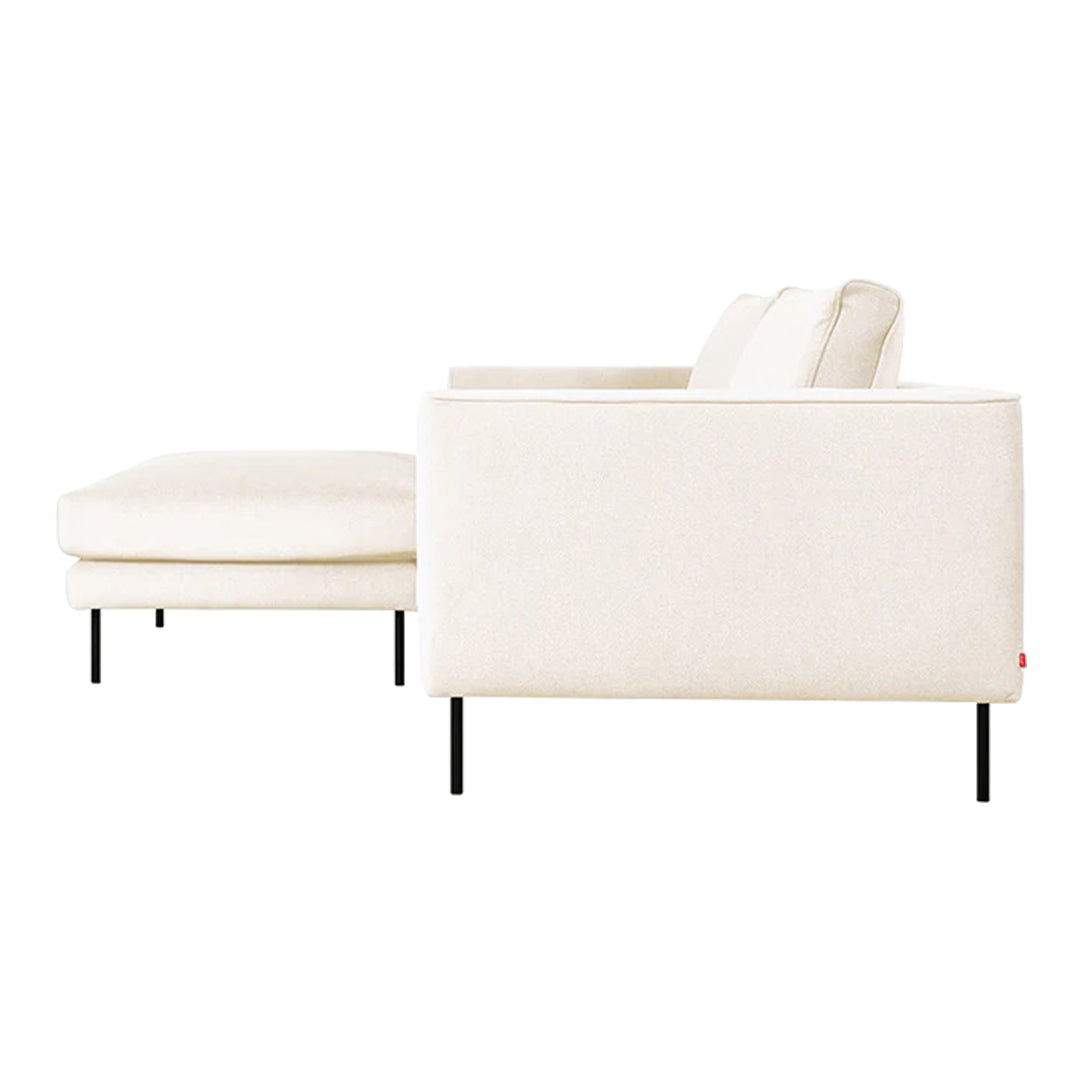 Light beige sofa with clean lines and minimalistic design, featuring smooth fabric and sleek black legs.
