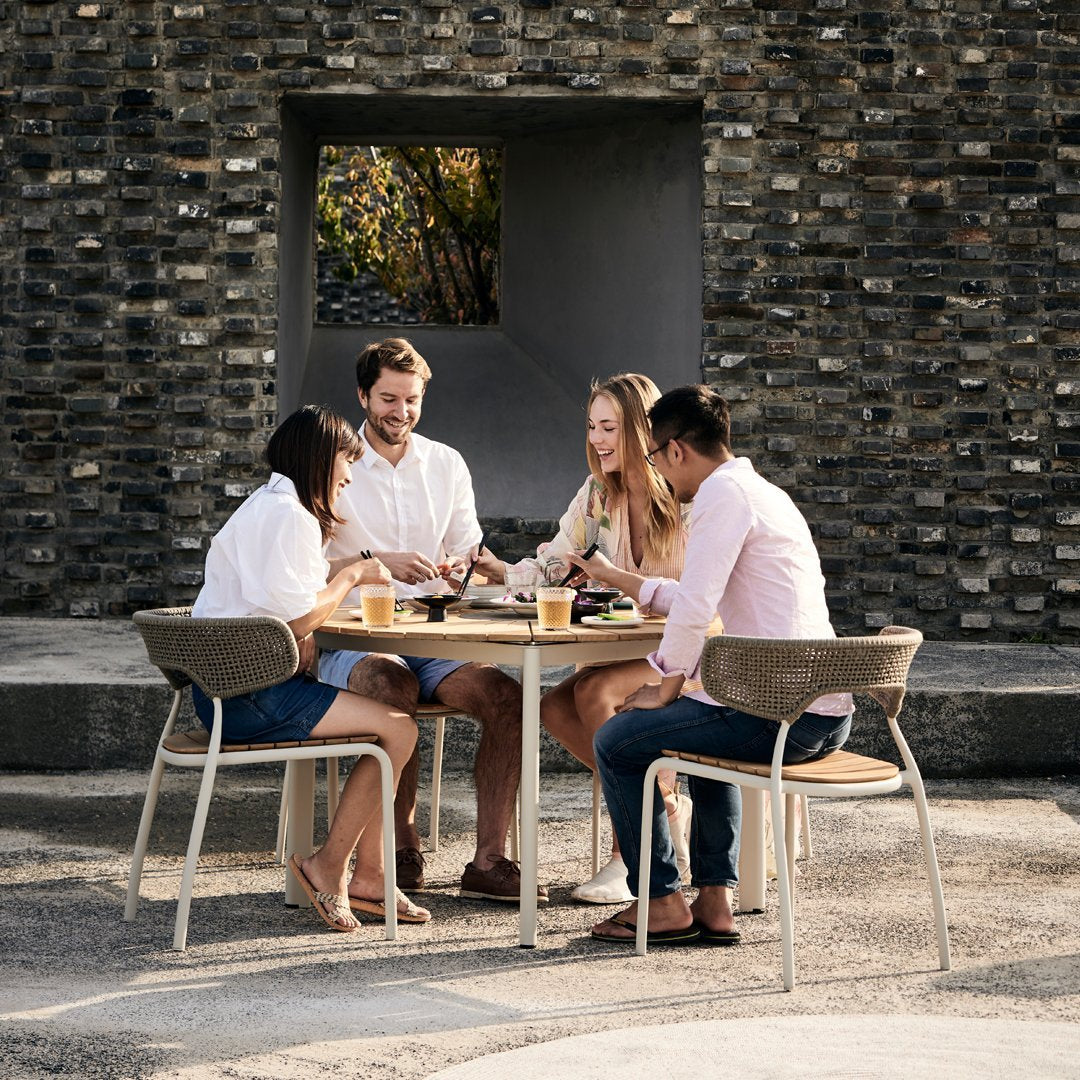 "Neutral tones of dining set with modern chairs, featuring soft beige and light gray against a natural stone backdrop."