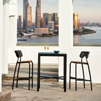Black metal bar table with wooden accents and two matching stools against a city skyline backdrop. Modern and stylish design.