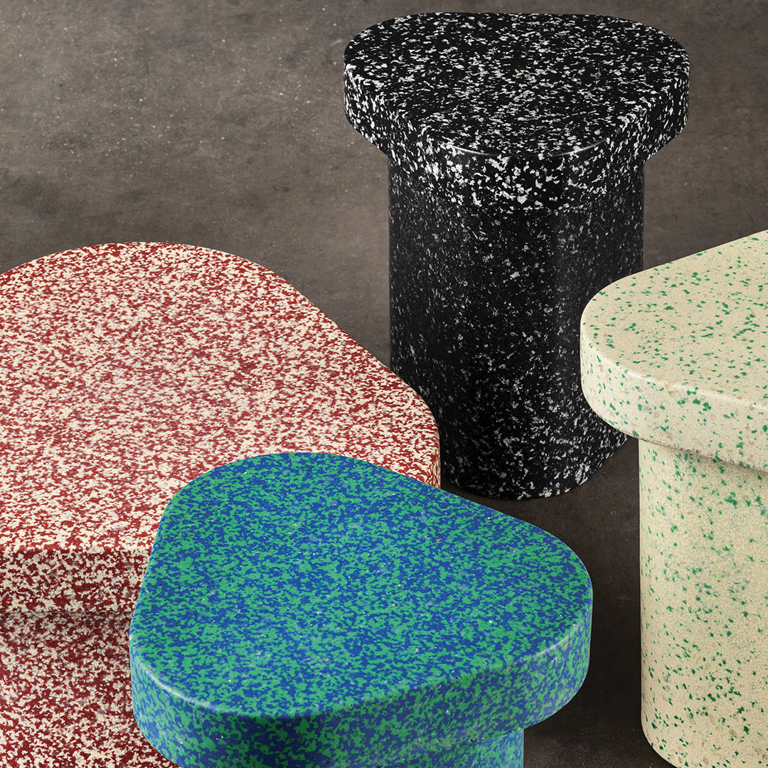 Colorful speckled table set featuring red, green, black, and beige patterns on modern shapes.