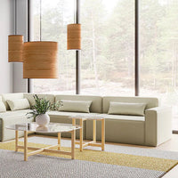 Light green sofa with neutral pillows, natural wood accents, and a geometric patterned rug in serene indoor setting.