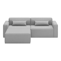 Gray sectional sofa with clean lines and two accent pillows, showcasing a modern, minimalist style.