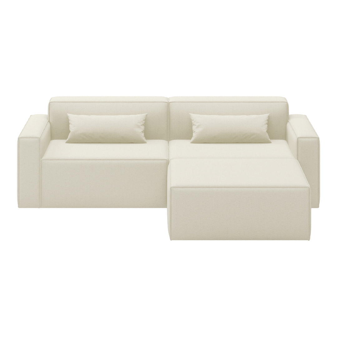 Cream-colored sectional sofa with a smooth, modern design and two matching throw pillows.