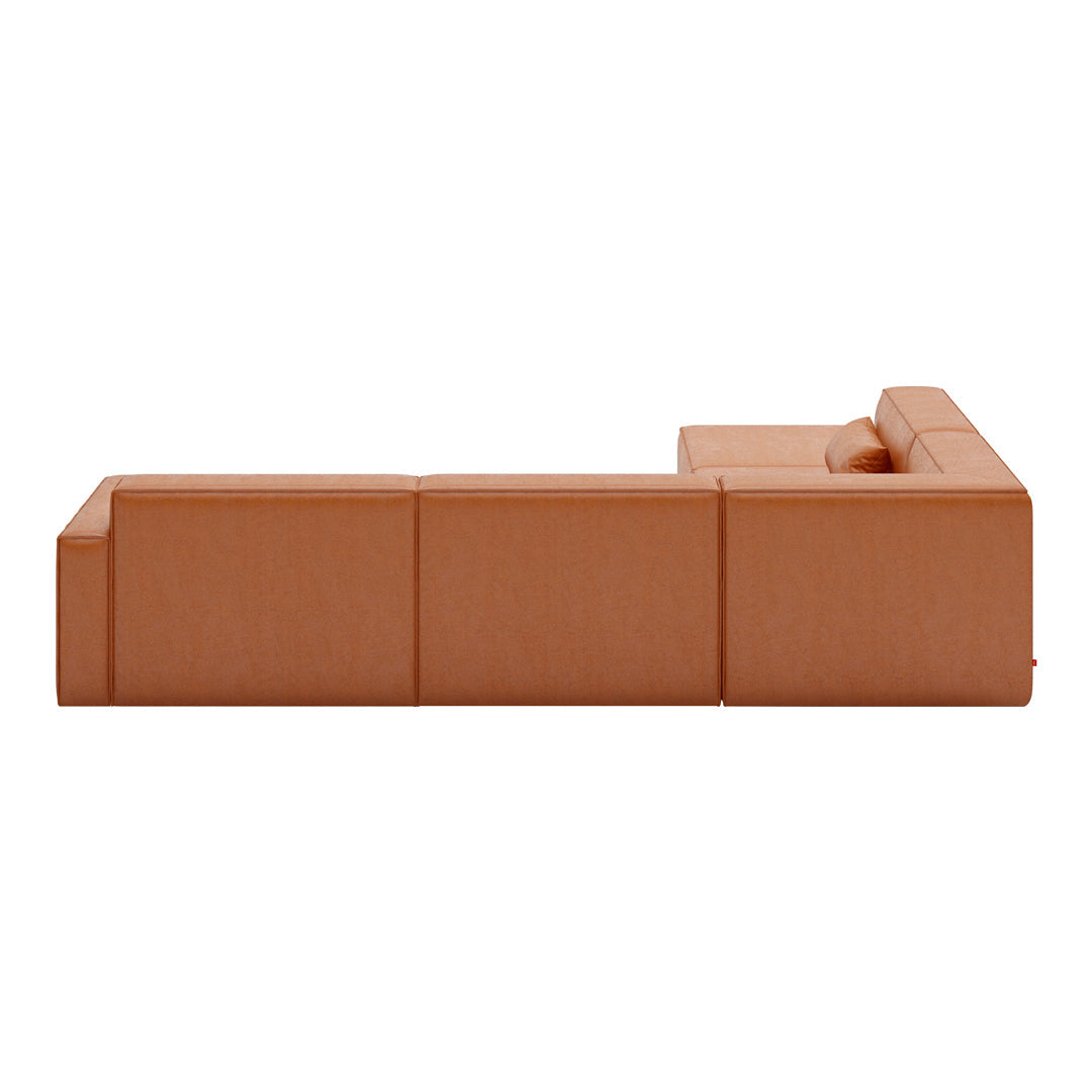 Modern L-shaped sofa in a warm terracotta hue with a smooth, minimalist design. Ideal for contemporary living spaces.