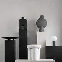 Stylish black and white decorative sculptures with geometric patterns against a neutral background.