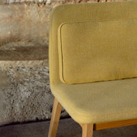 Yellow upholstered chair with a smooth finish, featuring a solid block color and minimalist design.