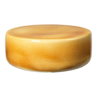 Glossy round table in warm amber and golden gradient, featuring smooth, subtle patterns and a sleek finish.