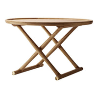Round wooden table in light beige with a natural finish and crossed base design. Ideal for modern decor.