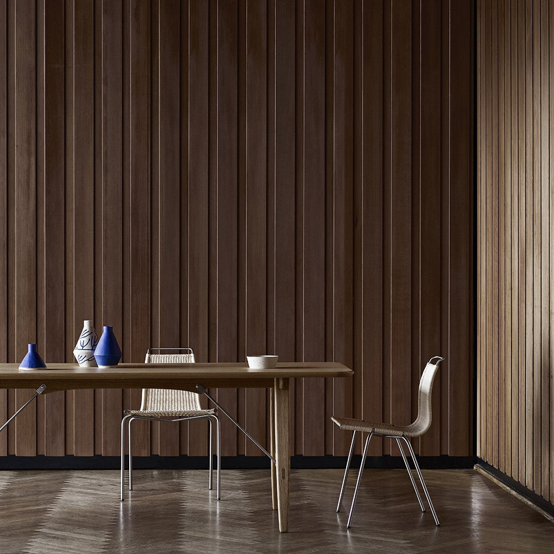 "Wooden wall paneling in rich brown tones with modern blue and white vases on a minimalist table. Contemporary design."