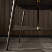 Dark wood chair with sleek lines and brass accents, showcasing a modern, minimalistic design.