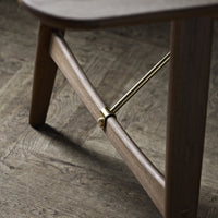 Wooden stool with a rich brown finish and gold metal accents, featuring a sleek, minimalist design.