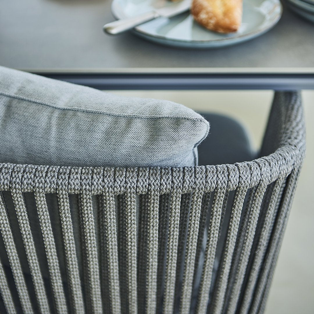 Gray woven chair with contrasting light gray cushion, featuring a modern horizontal stripe pattern.