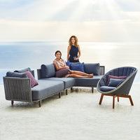 Stylish gray sectional sofa with purple and blue cushions, featuring a sleek, modern design against a scenic backdrop.