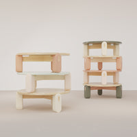 Modern stackable wooden shelves in soft pastel colors: mint green, peach, cream, and earthy tones.