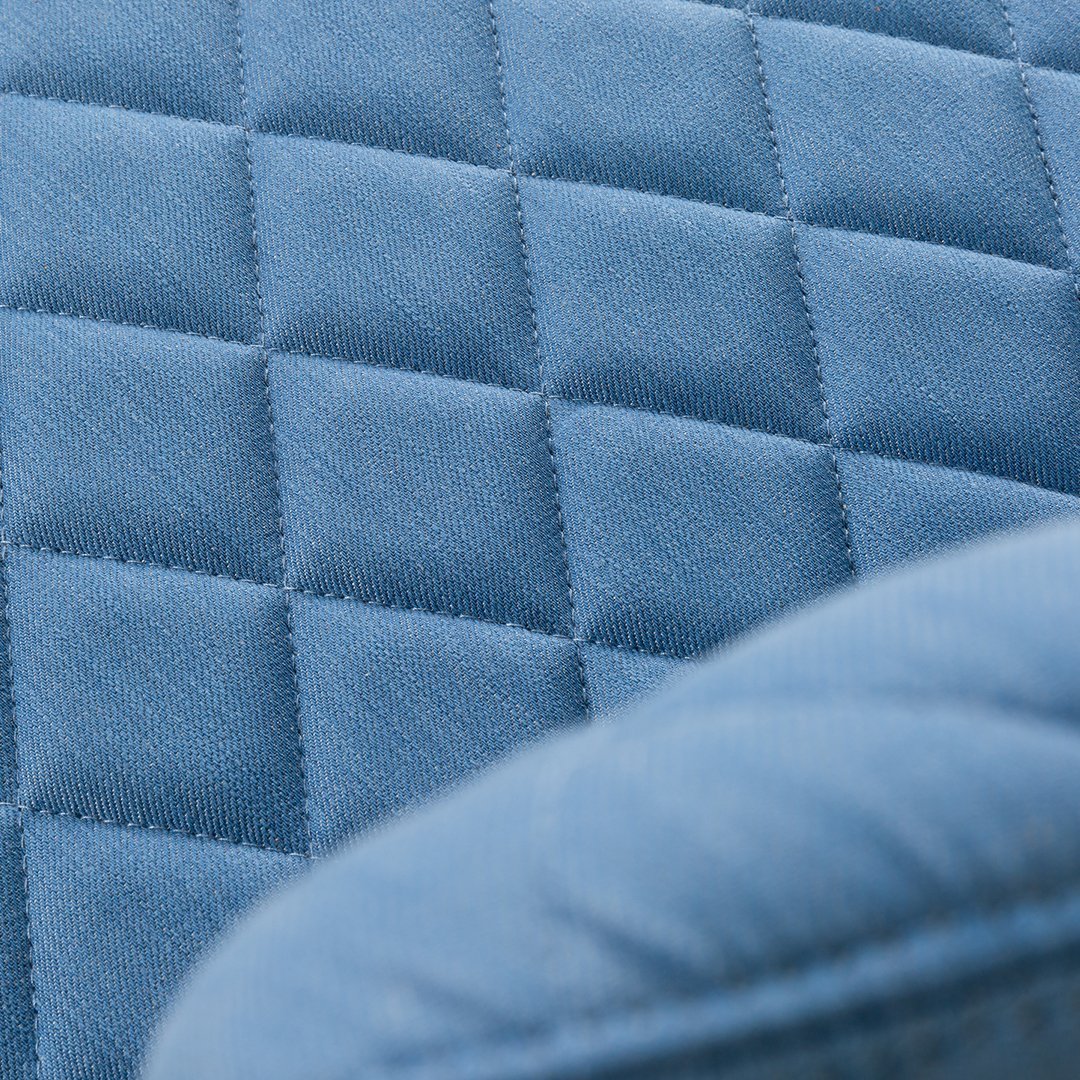 Close-up of quilted blue fabric featuring a textured diamond pattern. Ideal for modern home decor.