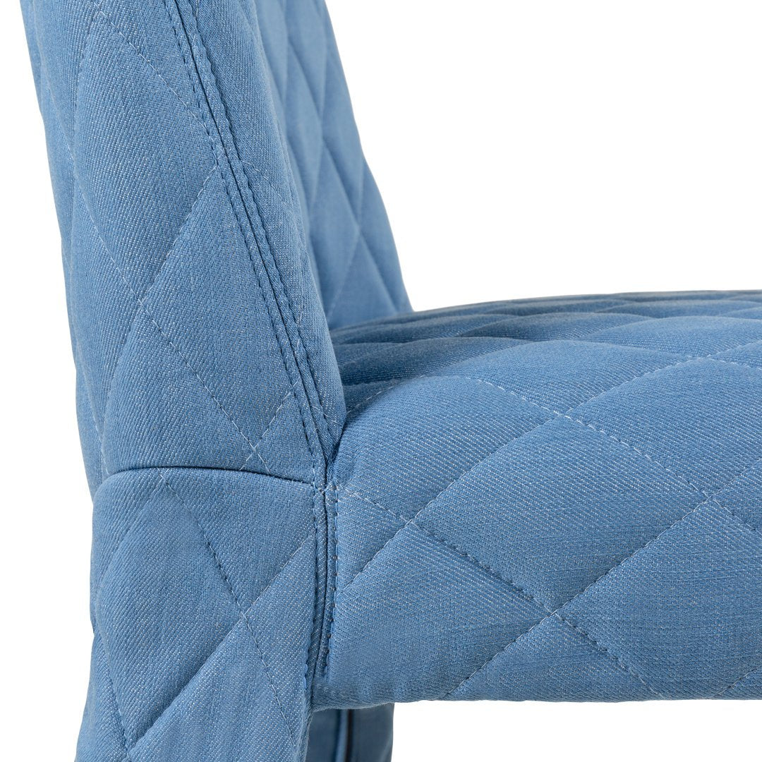 Quilted blue fabric chair with a soft texture and diamond pattern, perfect for stylish home décor.