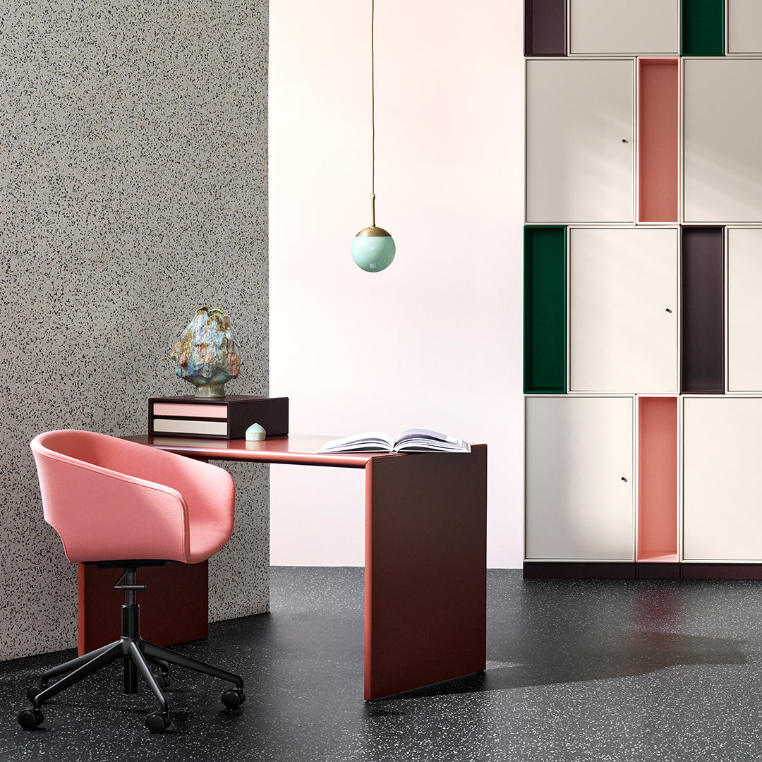Contemporary desk in pink and burgundy, against a speckled wall; stylish storage in green and cream accents.